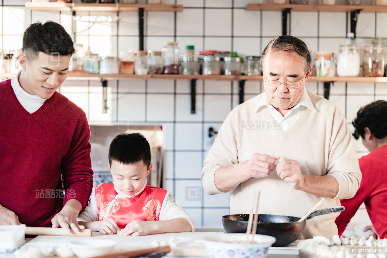 爸爸和爷爷在教小男孩包饺子