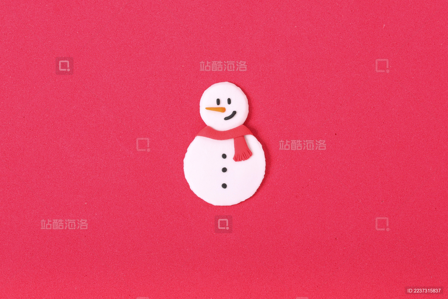 红色海绵纸上摆放彩色粘土捏制的披着红色围巾的雪人