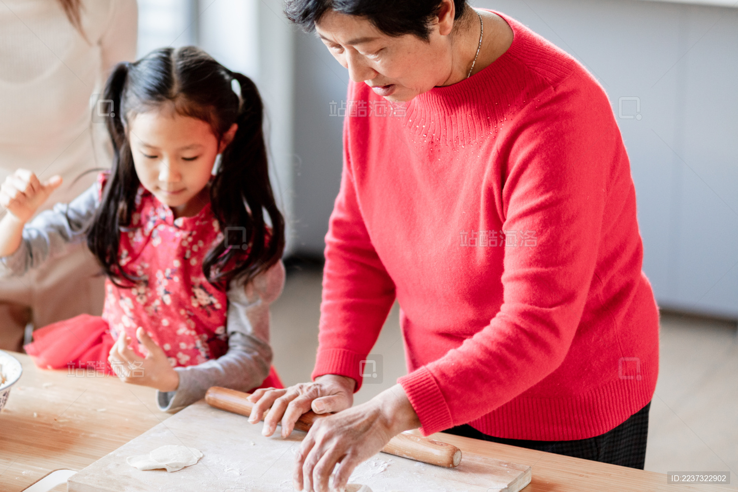 奶奶和妈妈教小女孩包饺子