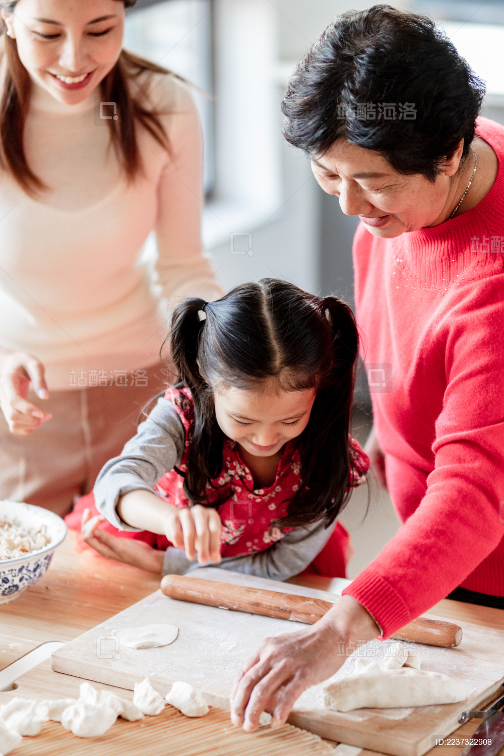 奶奶和妈妈教小女孩包饺子