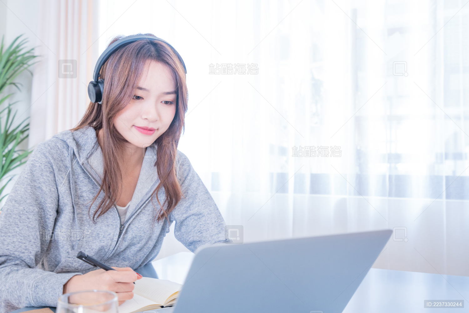 一名年轻的亚洲女子在坐在餐厅一边吃早餐一边