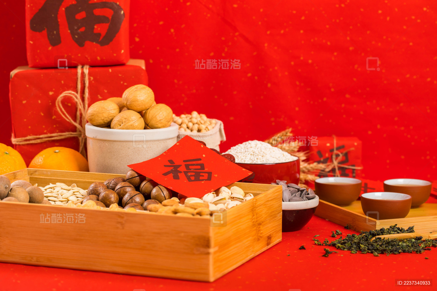 果盒上放着对联福字 旁边还摆着很多年货食品