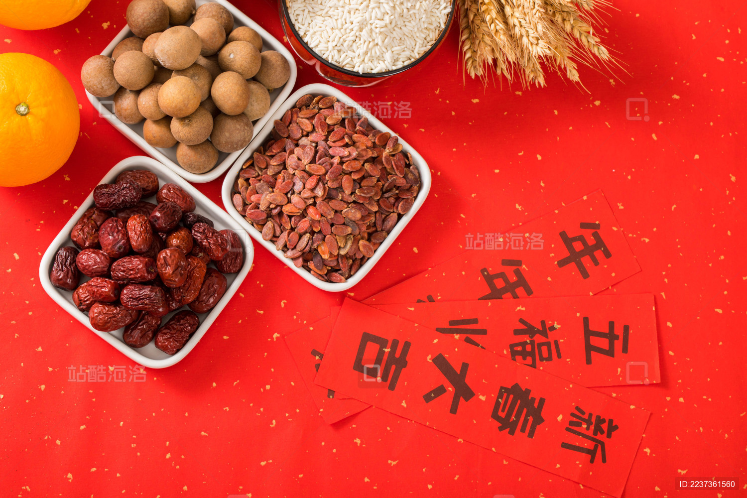 用瓷碟装有坚果和水果及对联放在红色背景上