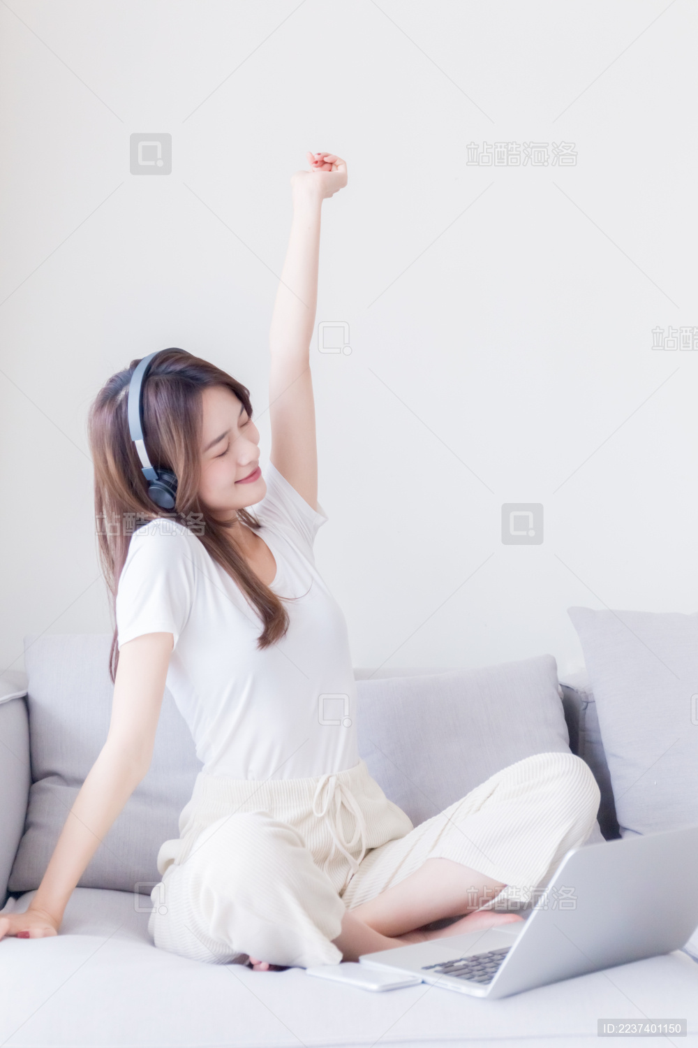 坐在沙发上听音乐的年轻女孩