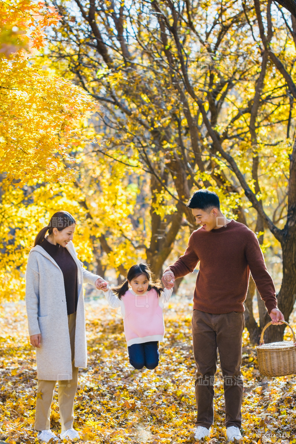 一家三口在秋天的树林里玩耍