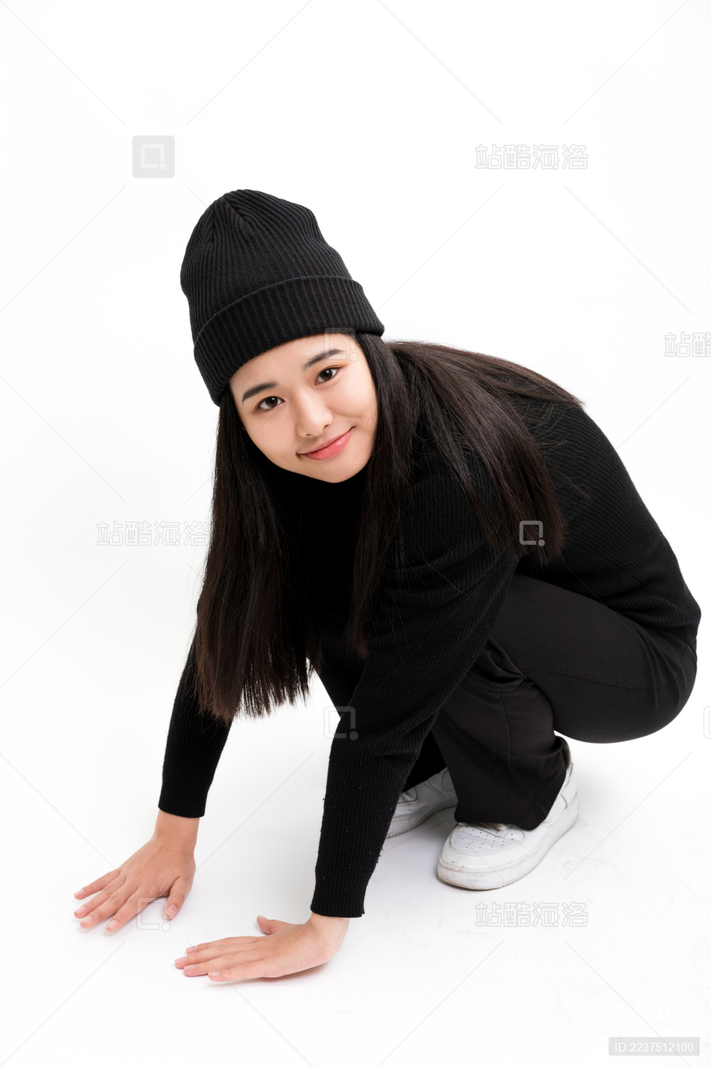 蹲着双手撑地看镜头的年轻女性