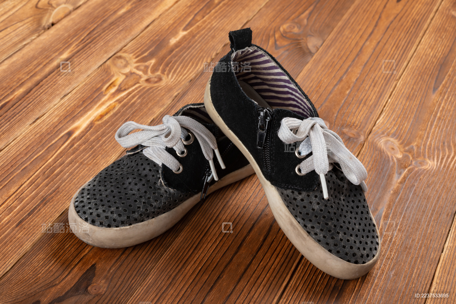 置于木板上的一双旧青少年运动鞋