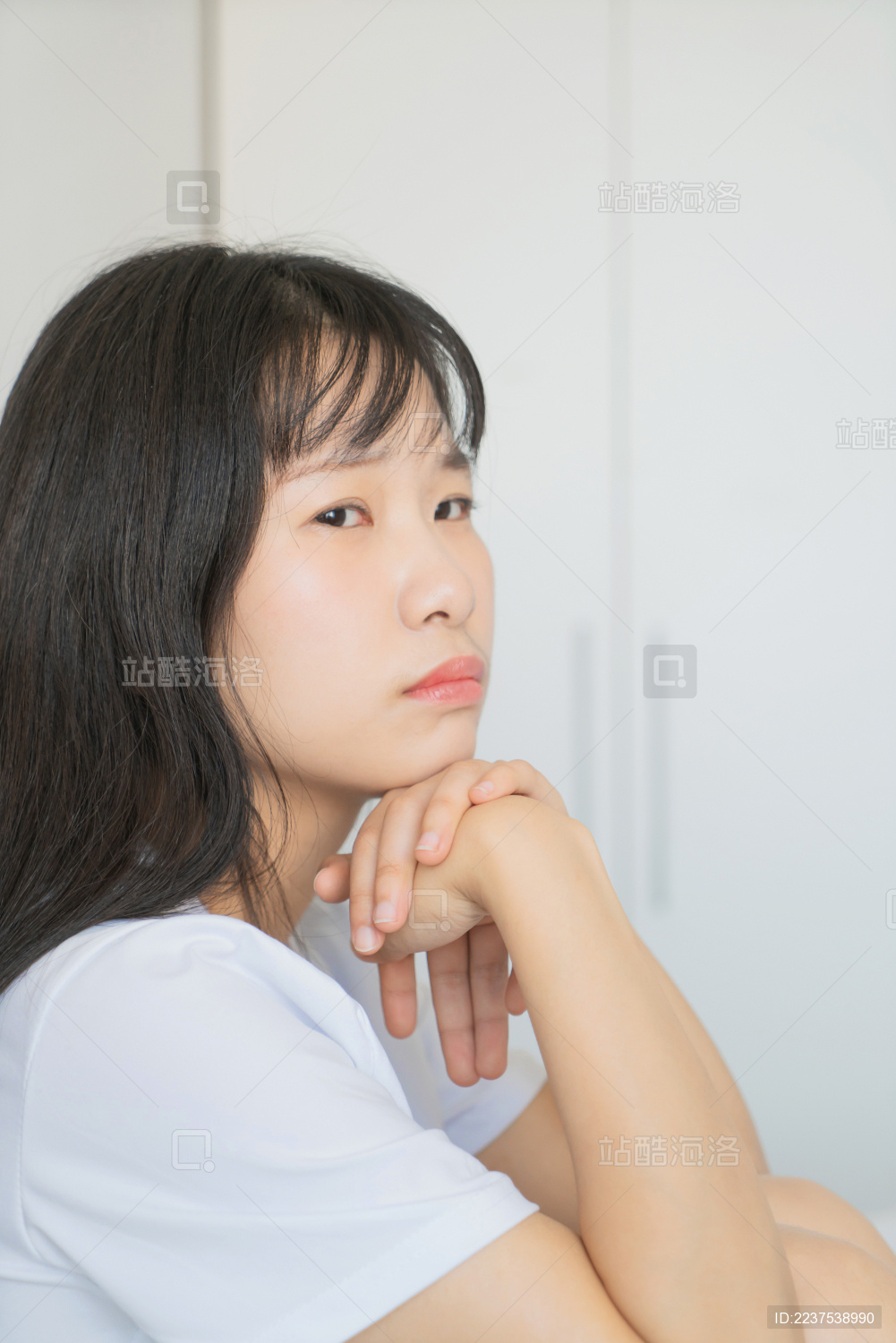 中国年轻女生在卧室床上陷入沉思