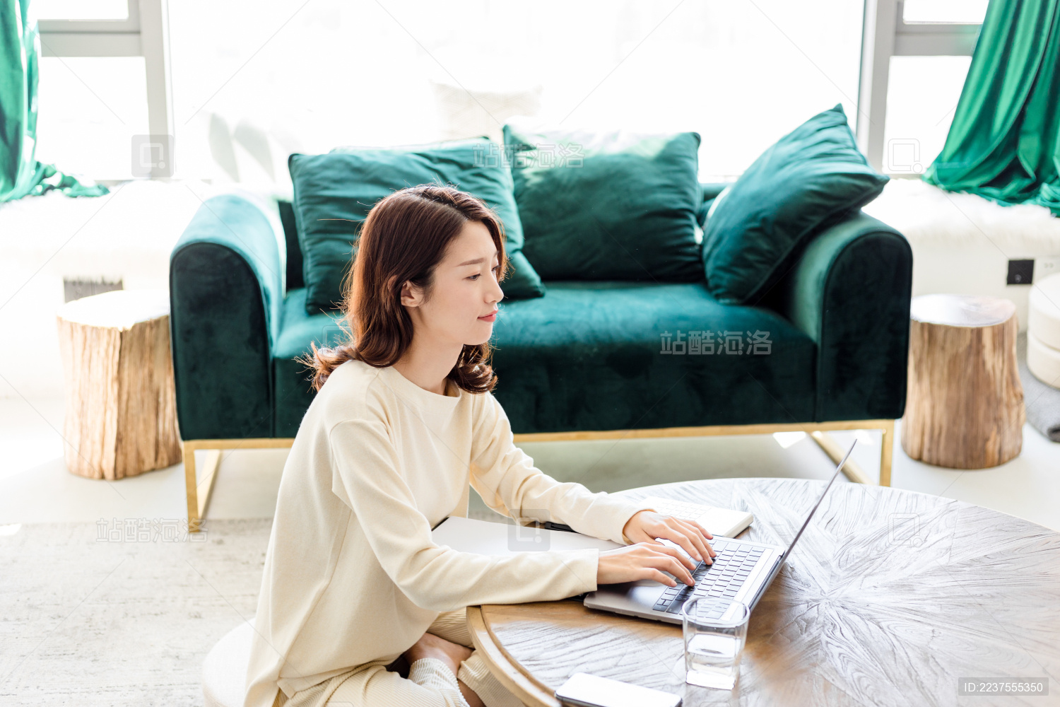 一名年轻女姓在客厅里使用手提电脑进行办公