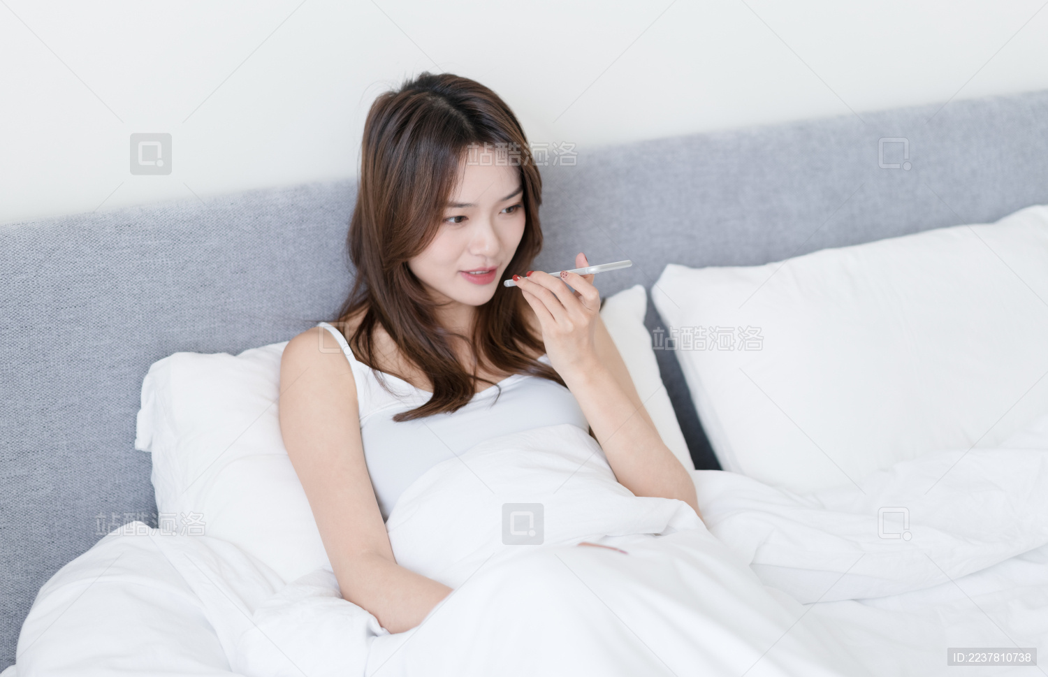 女生坐在床上使用手机