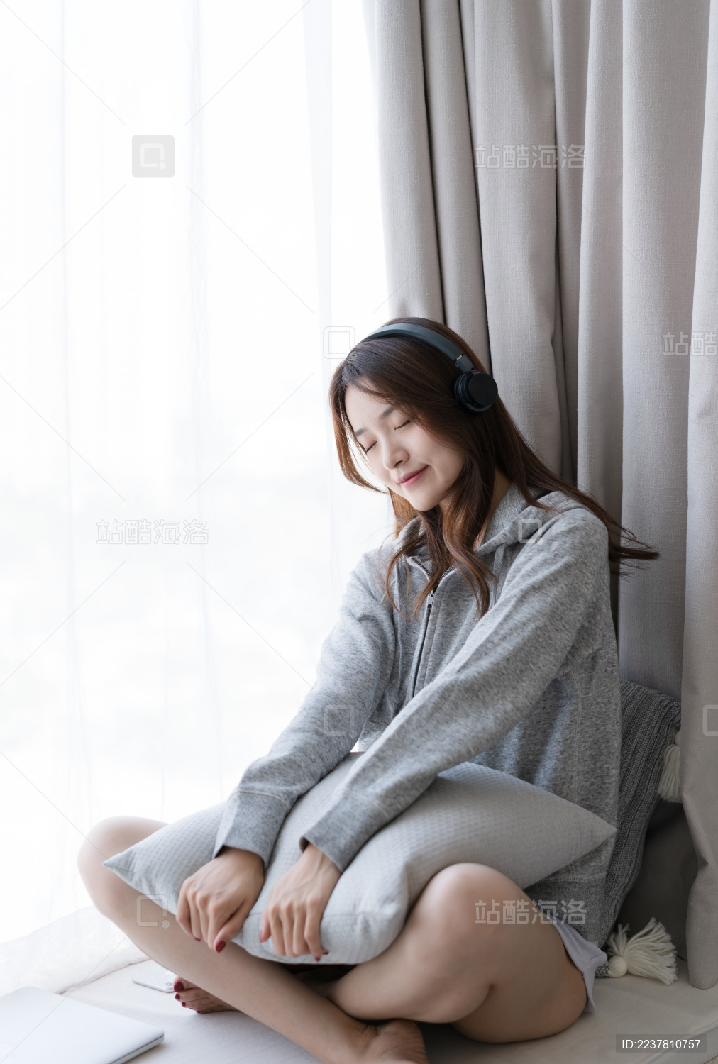 女生坐在窗户边听音乐