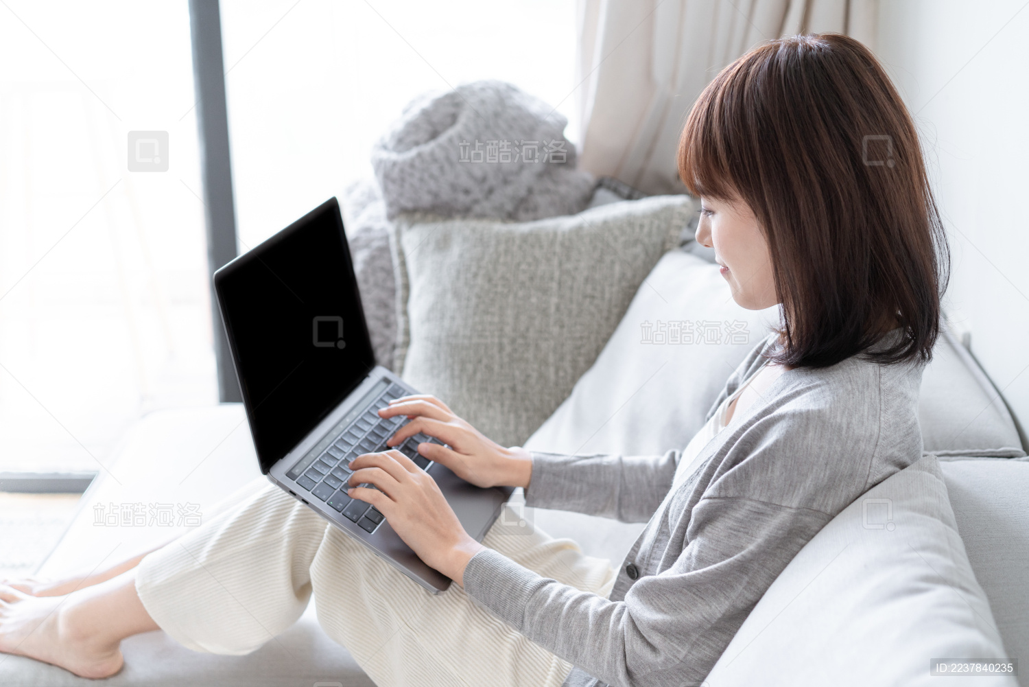 亚洲女生靠在沙发上用电脑办公