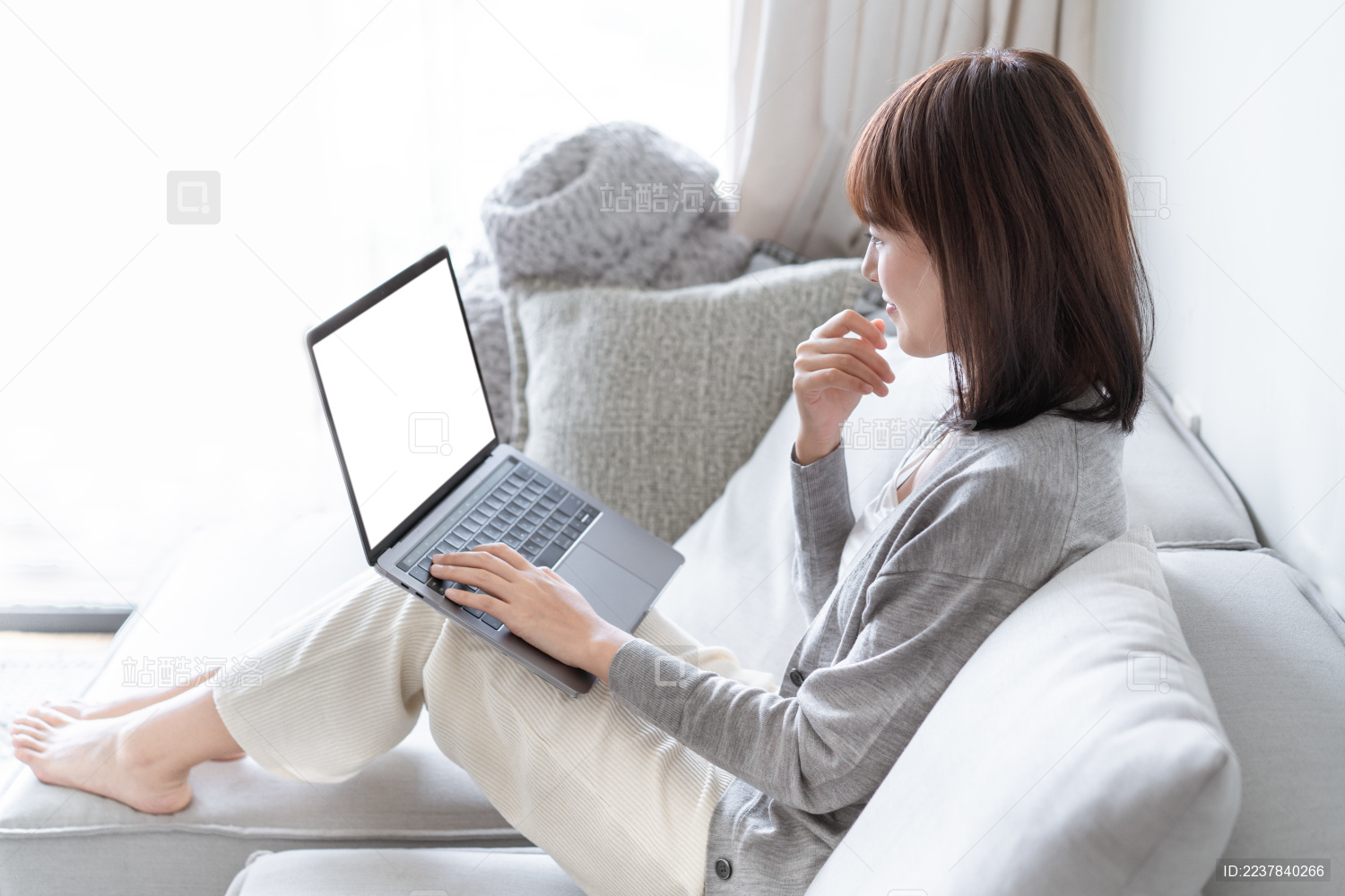 亚洲女生靠在沙发上用电脑办公