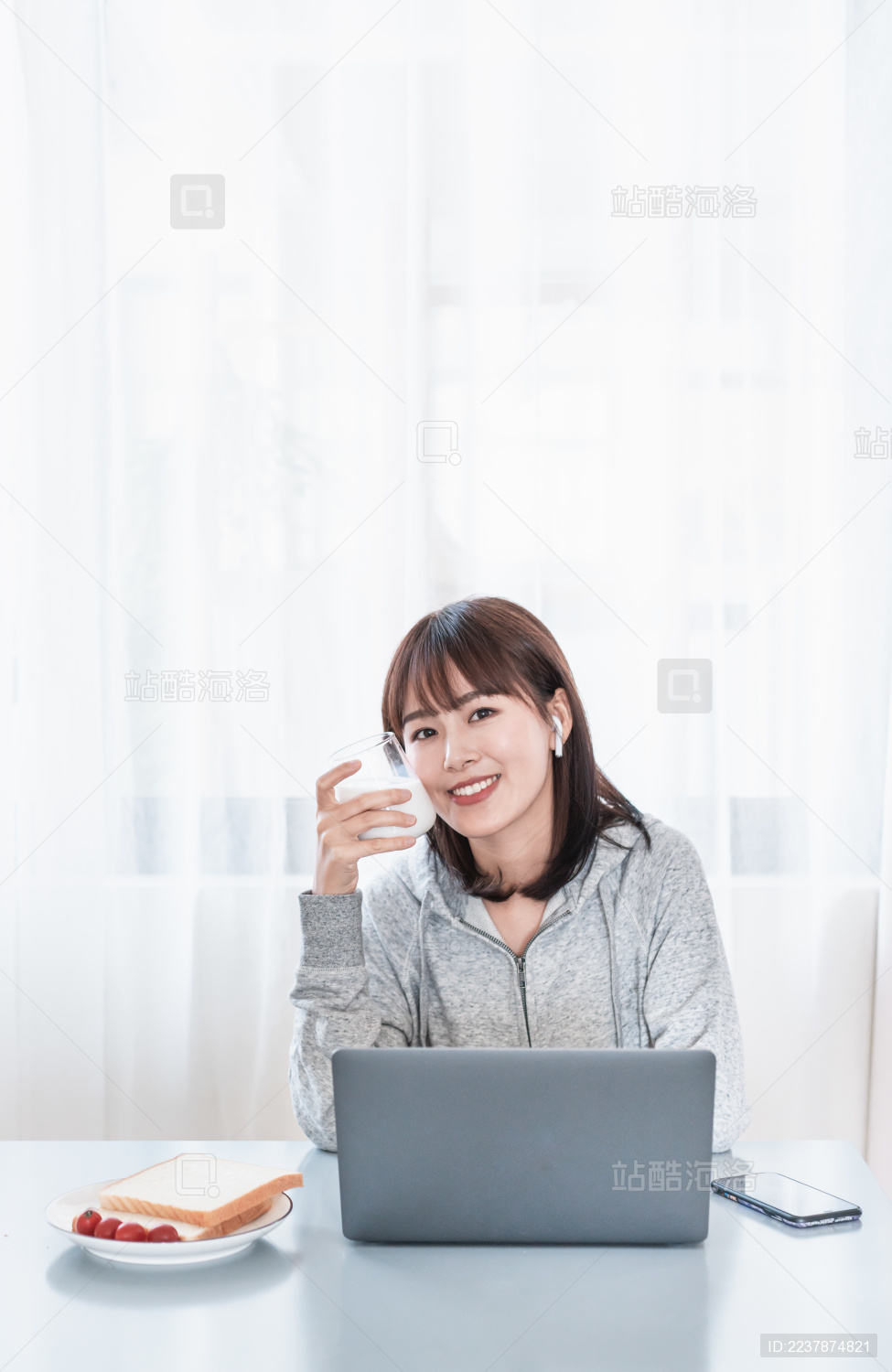 年轻女性一边吃早餐一边办公