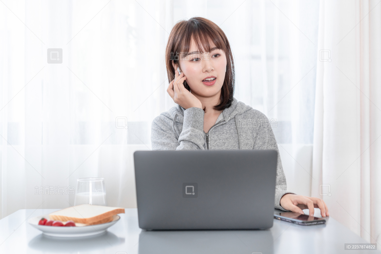 年轻女性一边吃早餐一边工作接电话