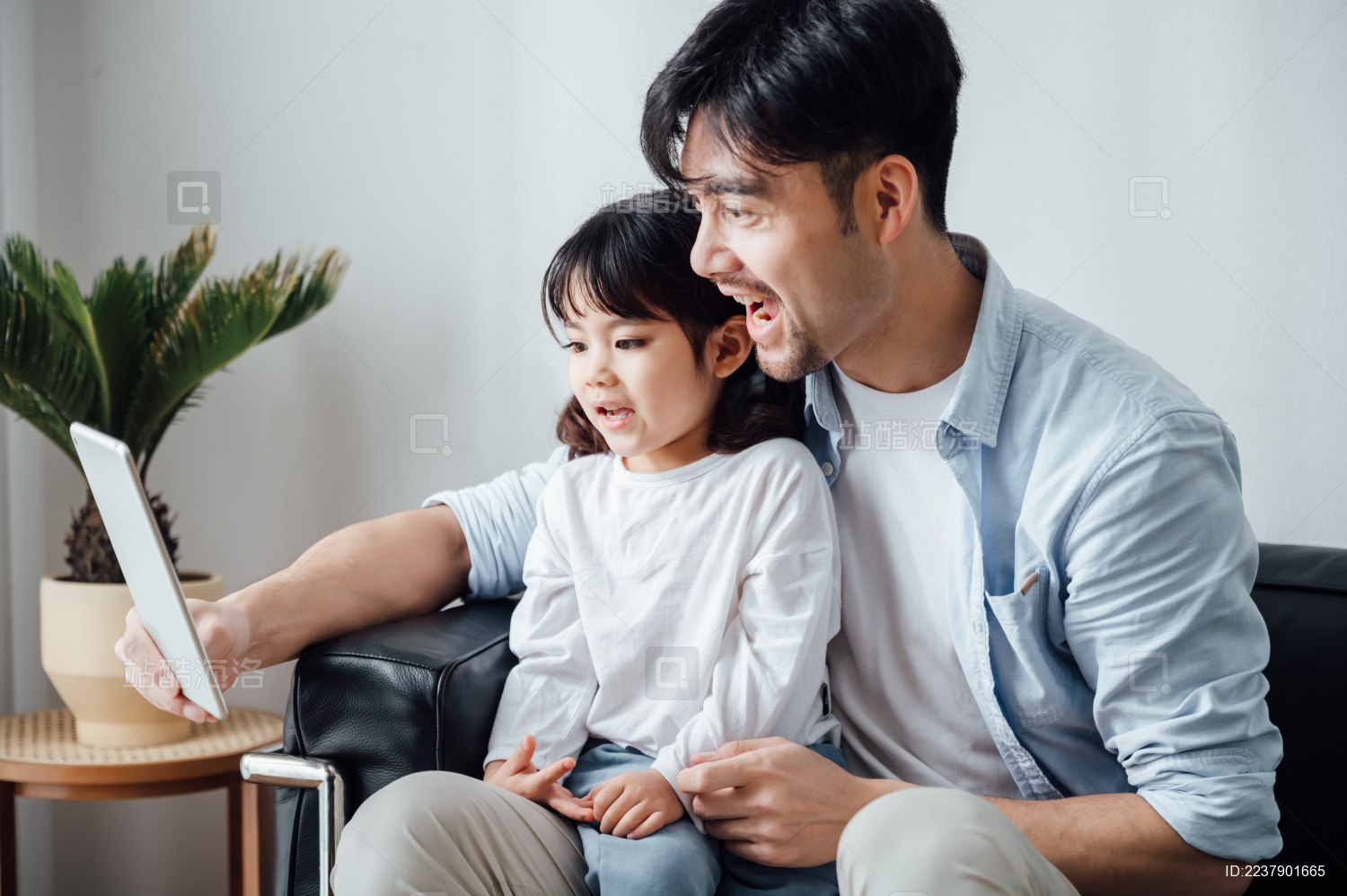 爸爸和女儿在家使用平板电脑