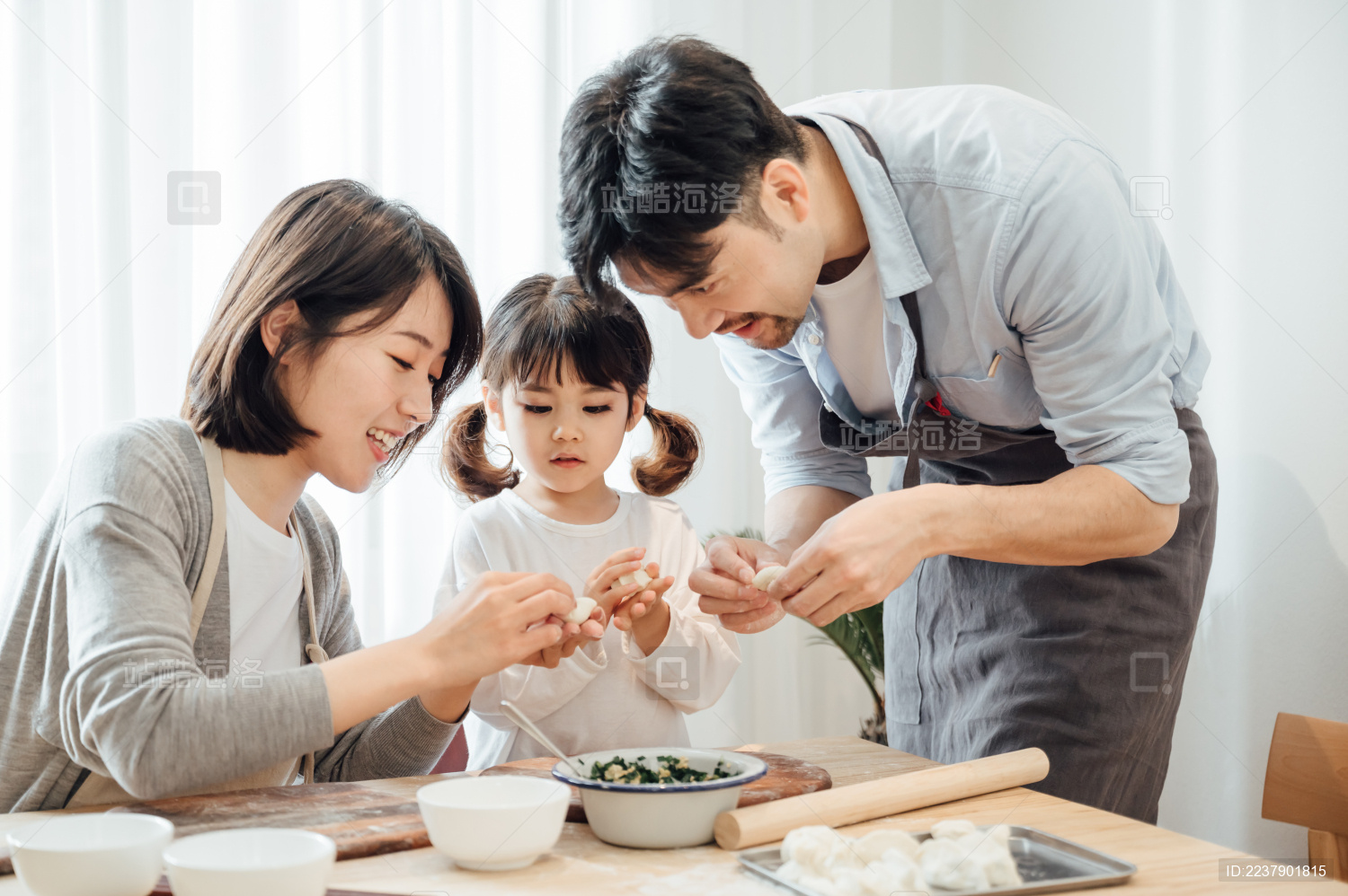 爸爸妈妈和女儿在家包饺子