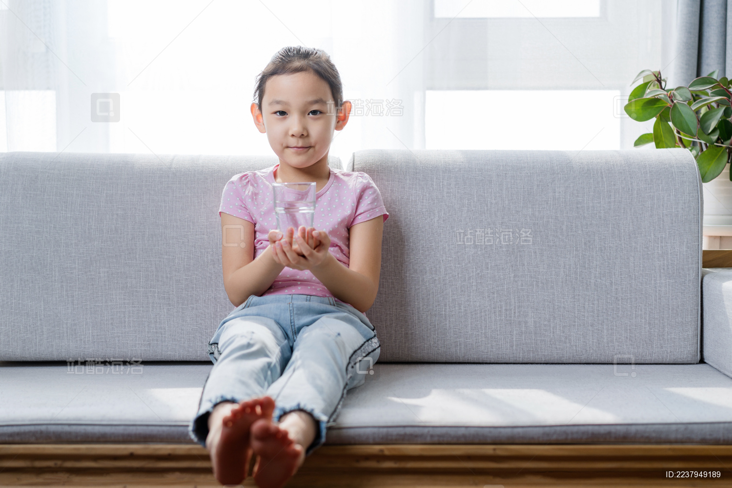 坐在沙发上喝水休息的中国女孩