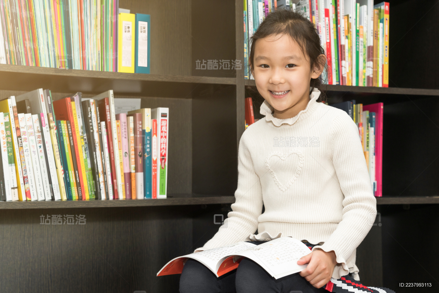 坐在书架前认真读书的中国女孩