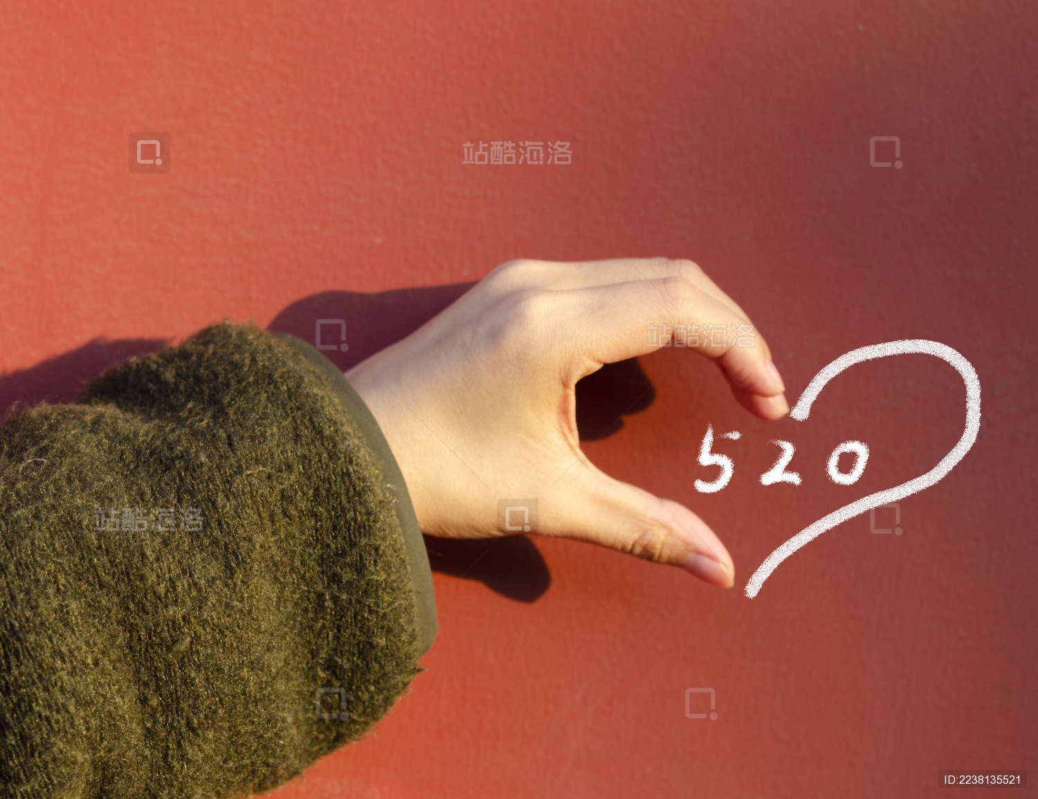 手与墙上的粉笔拼出一个完整的心形 围着数