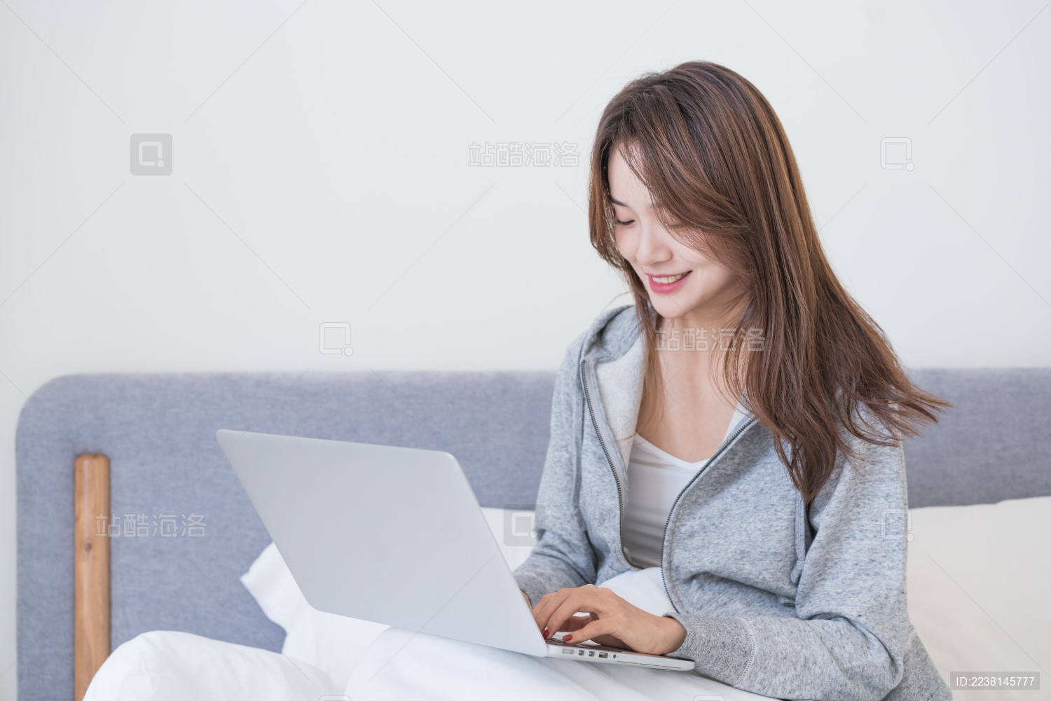 年轻女性在床上使用电脑工作