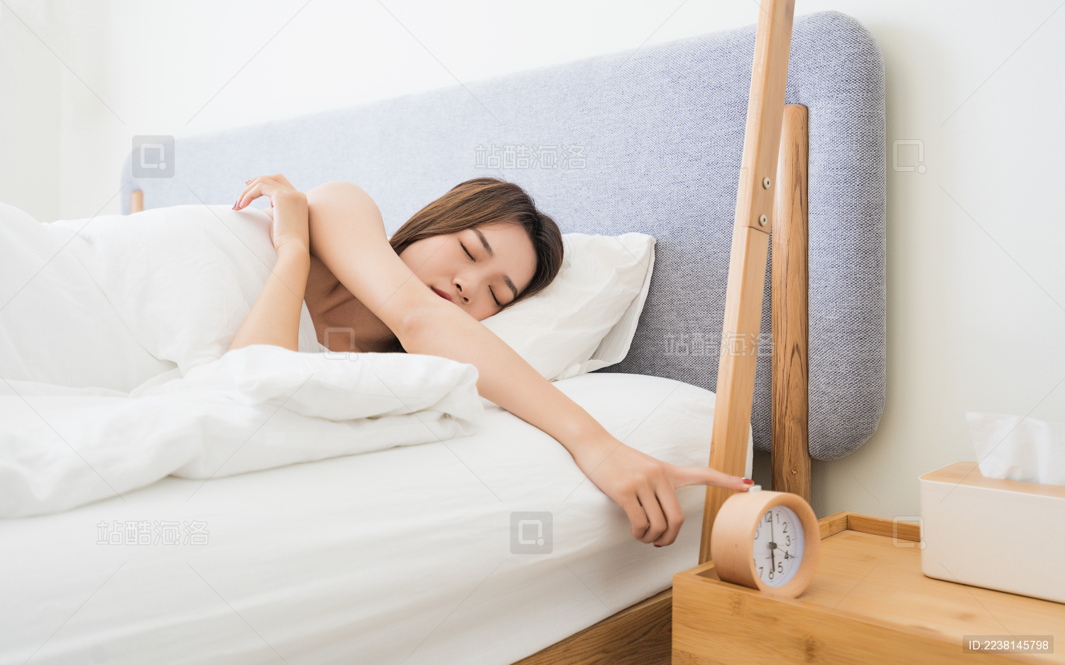 亚裔女性正要起床 伸手关闭闹钟