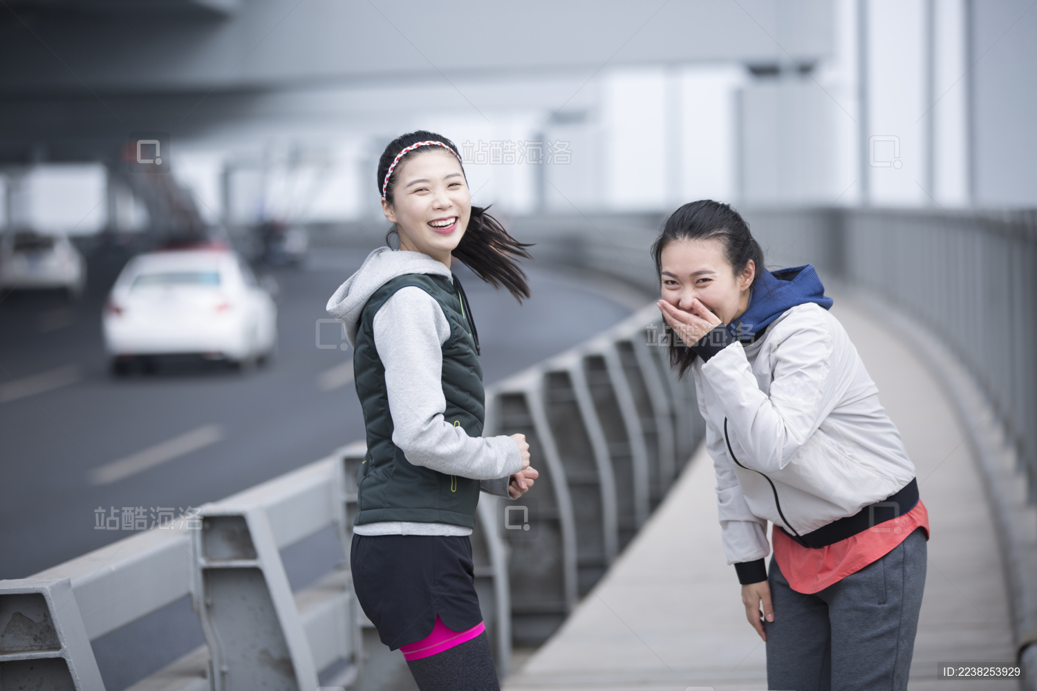 两个青年女子在跨海大桥上跑步嬉戏