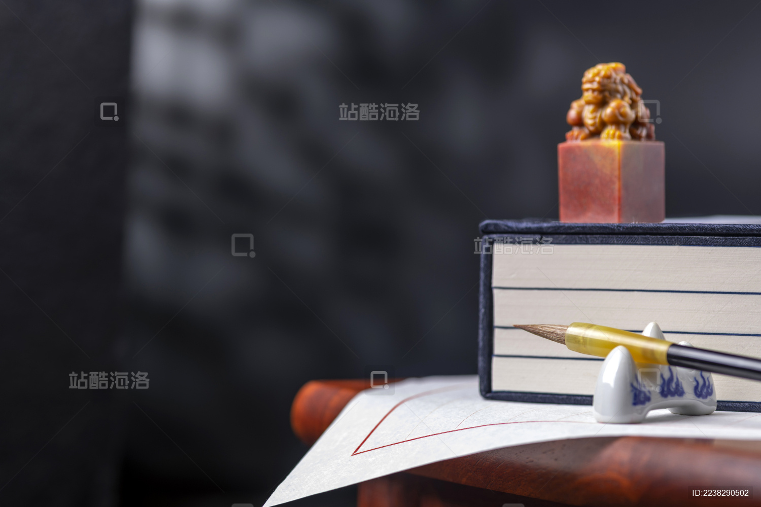 文房四宝毛笔宣纸线装书印章摆放在木桌面上