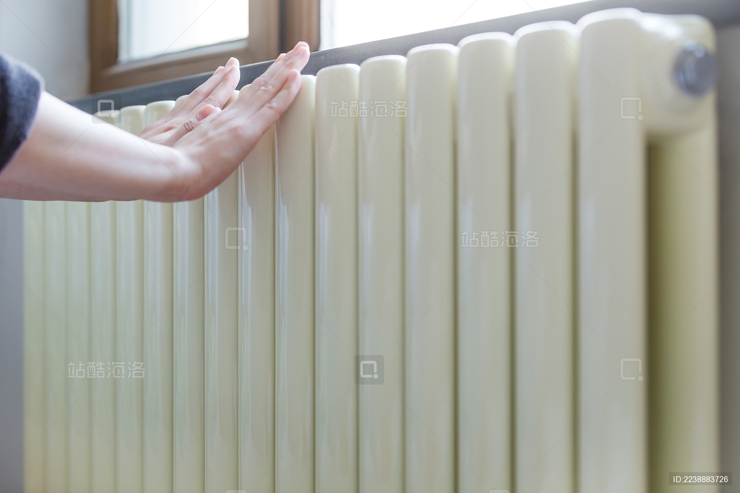 冬季北方开始供暖 把手放在暖气上取暖。