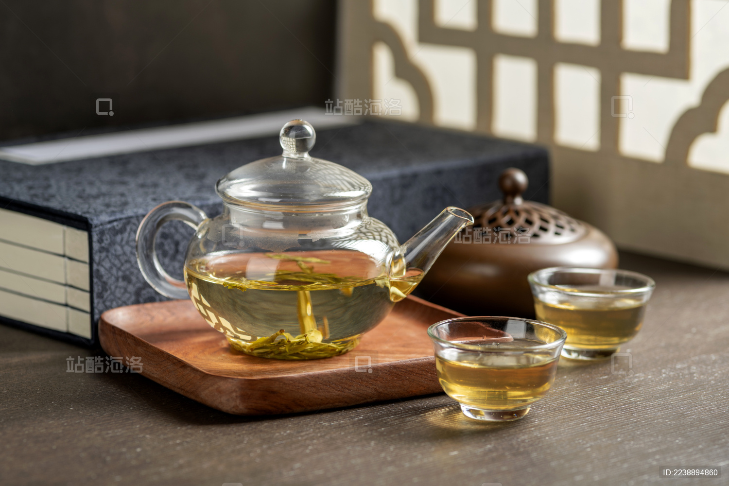 仿古玻璃茶壶冲泡的茶水摆放在窗棂影木桌面