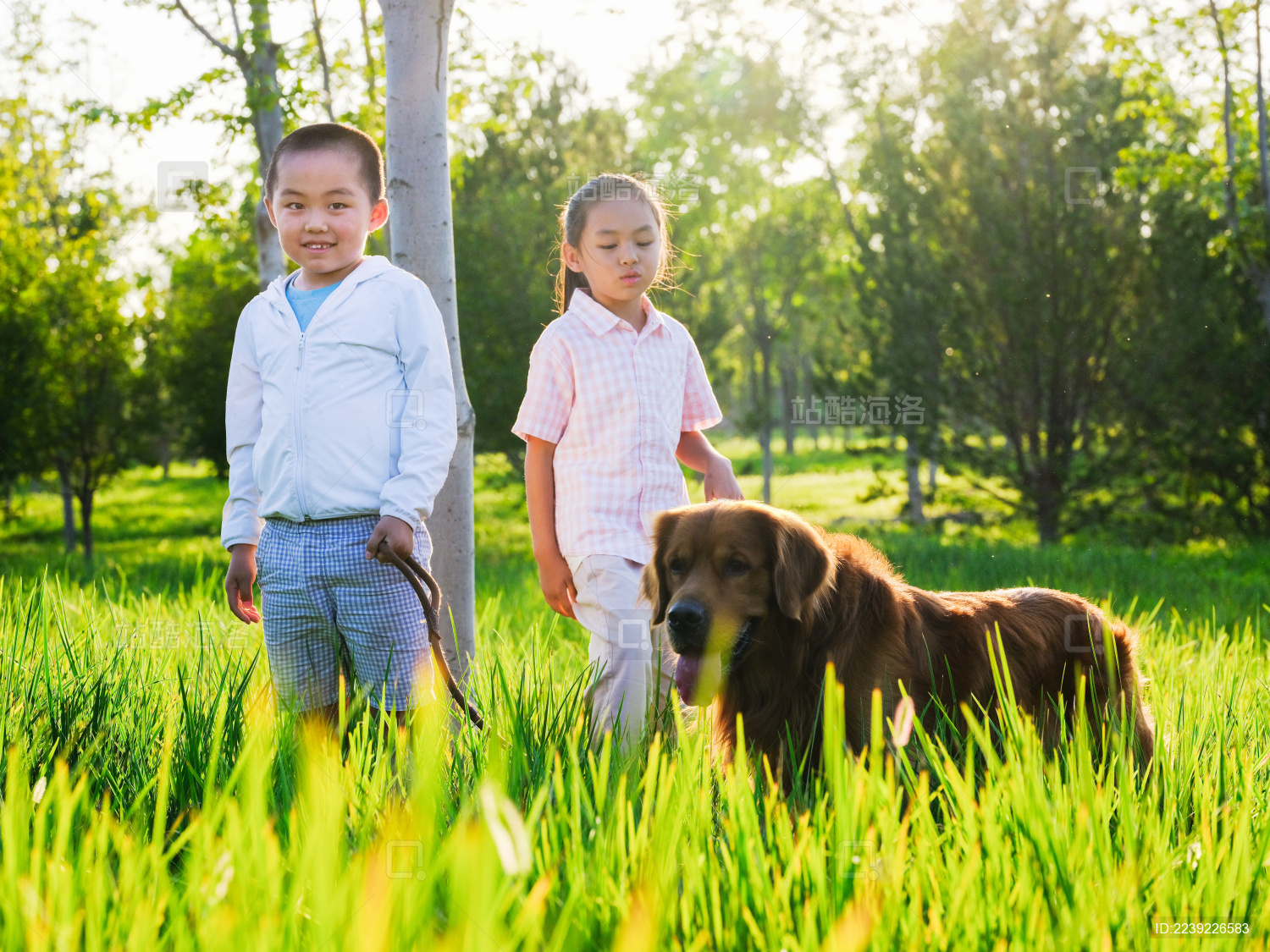 两个快乐的孩子在公园遛狗