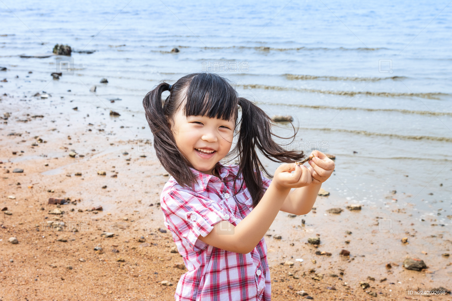 小女孩开心的双手抓着一只小螃蟹