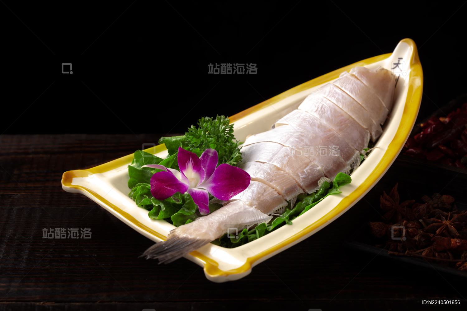 深色桌上白盘里的重庆老火锅菜品大耗儿鱼段