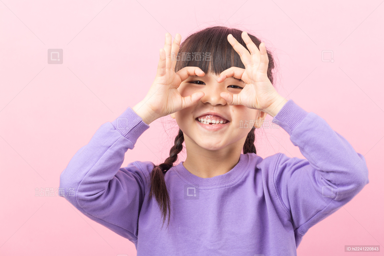 粉色背景前可爱的亚洲小女孩