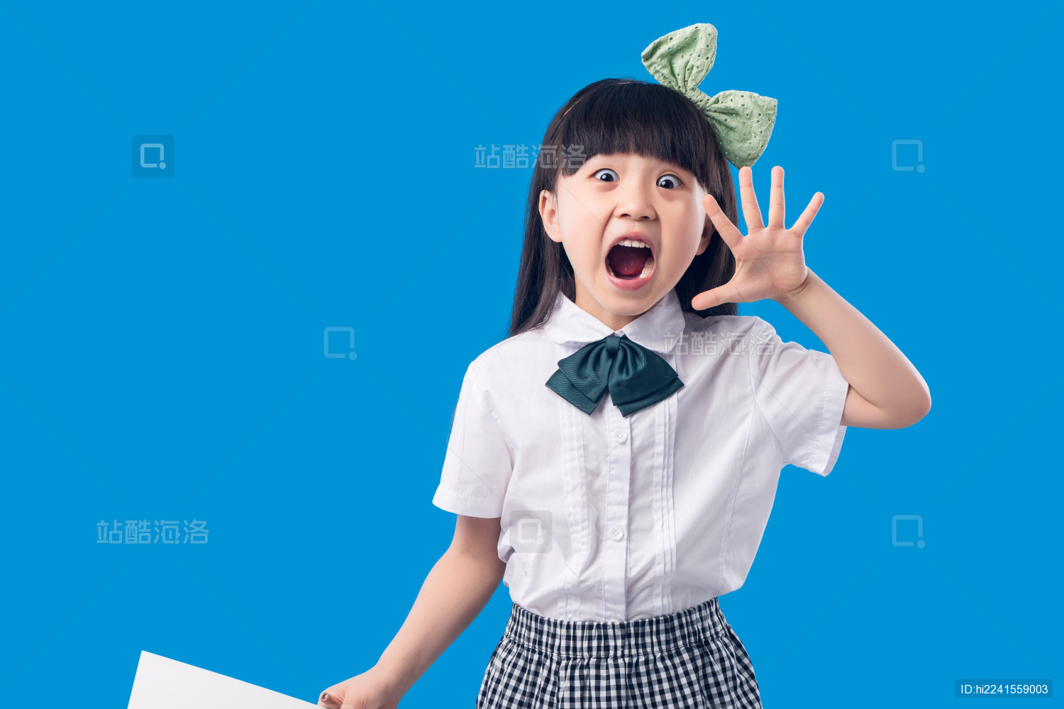 蓝色背景前的亚洲小女孩吃惊的表情