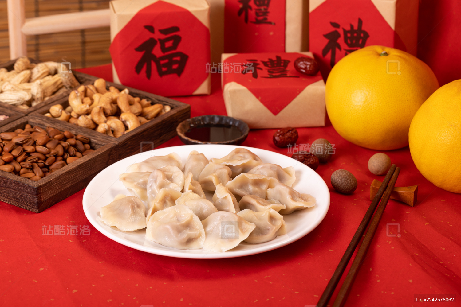 一盘饺子和年货礼盒放在红色桌子上