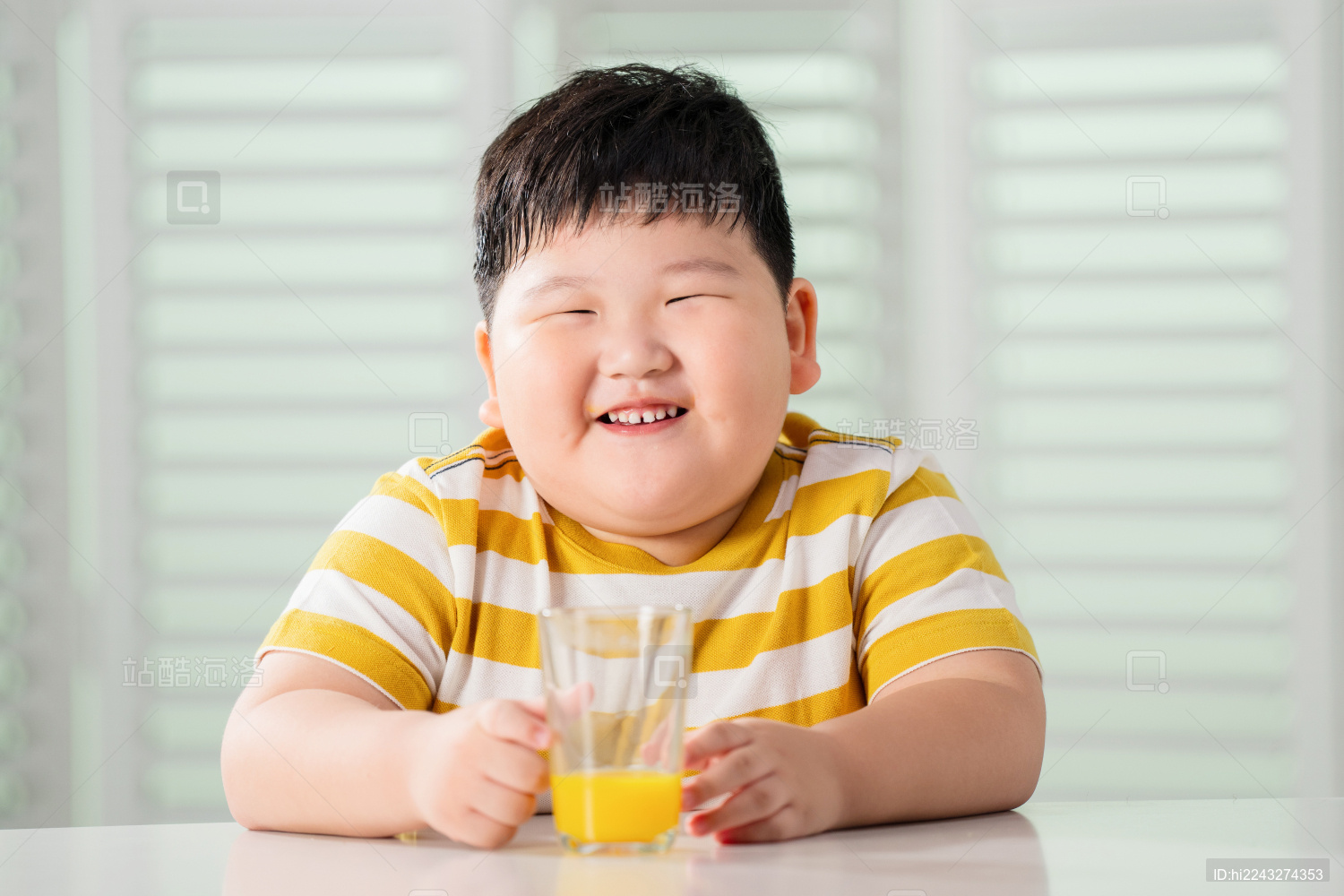 可爱的肥胖小男孩喝果汁