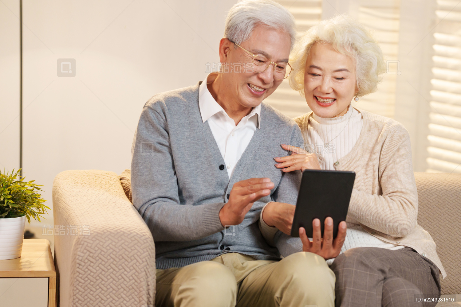 老年夫妇坐在沙发上使用平板电脑