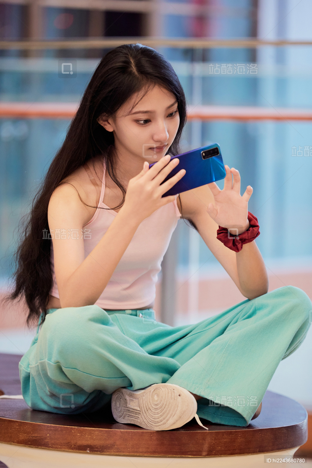 假日在商场休息区用手机自拍的中国少女