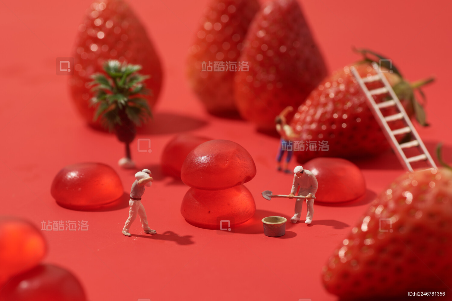 红色背景上软糖果草莓水果微缩小人创意拍摄