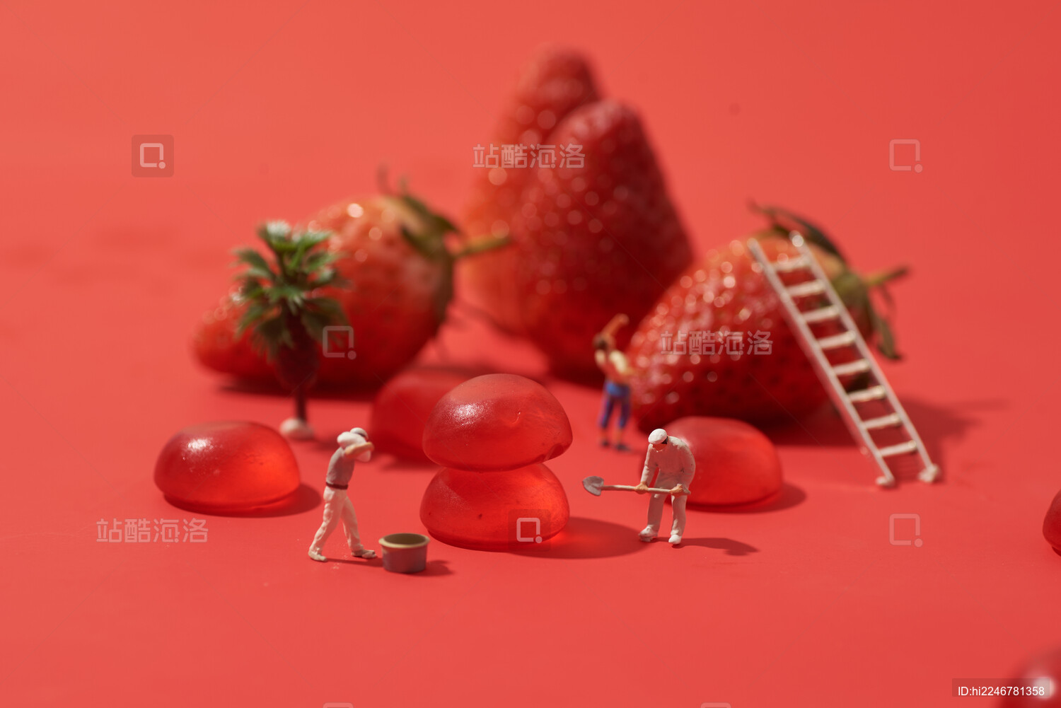 红色背景上软糖果草莓水果微缩小人创意拍摄
