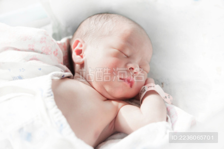 睡熟的初生婴儿裸露上身晒太阳