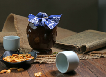 陶瓷酒瓶酒杯古书放在木桌上