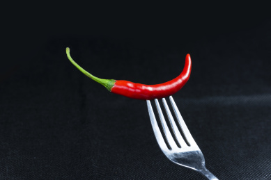 叉刺着红辣椒在黑色背景上