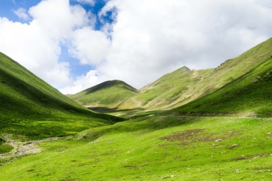 蓝天白云下的草地与公路