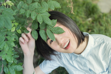 躲在叶子后的快乐女孩