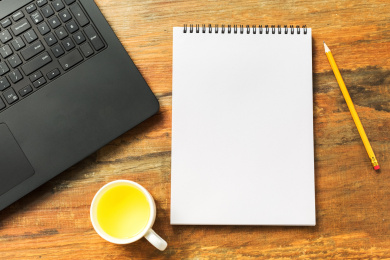 办公桌上的空白笔记本和电脑