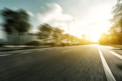 与阳光下的树木空柏油路