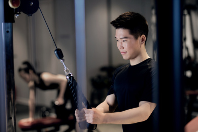 一年轻男性在健身房锻炼手臂
