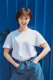 一位年轻女孩站在蓝色背景墙前